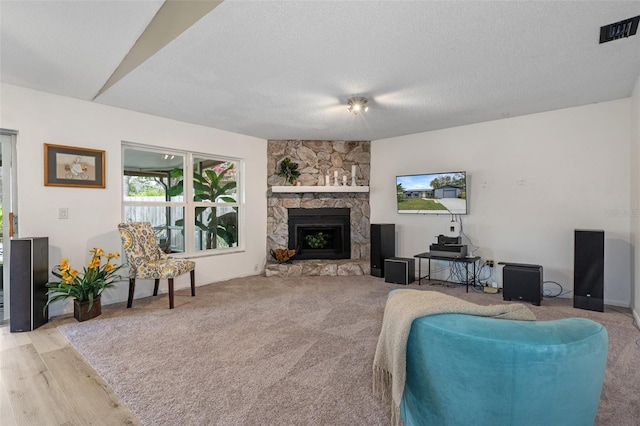 living room featuring a fireplace, light hardwood / wood-style floors, and a textured ceiling