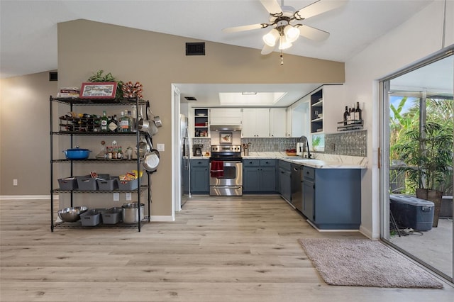 kitchen with sink, stainless steel appliances, lofted ceiling, white cabinets, and light wood-type flooring