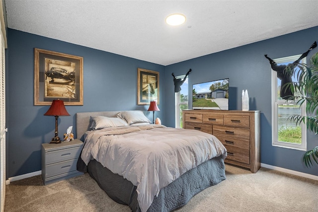 bedroom featuring a textured ceiling and light colored carpet