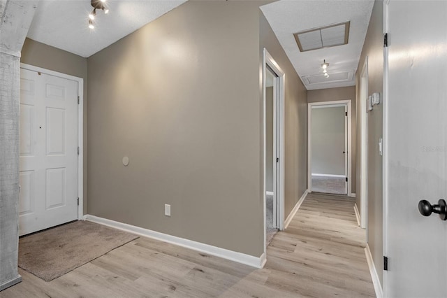 interior space with a textured ceiling and light hardwood / wood-style flooring