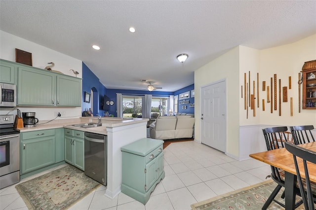 kitchen featuring appliances with stainless steel finishes, a textured ceiling, ceiling fan, and green cabinets