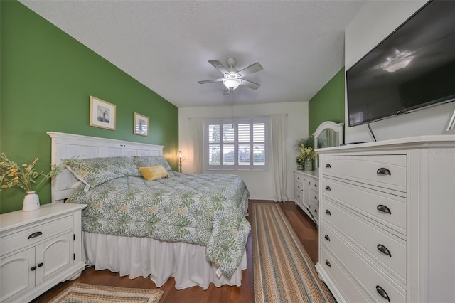 bedroom featuring ceiling fan, dark hardwood / wood-style flooring, and a textured ceiling