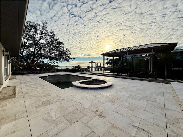 patio terrace at dusk featuring a gazebo and an outdoor fire pit