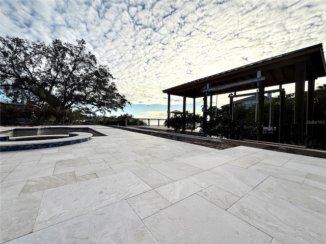 view of patio featuring an in ground hot tub