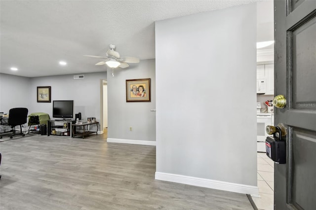 office area featuring a textured ceiling, light hardwood / wood-style floors, and ceiling fan