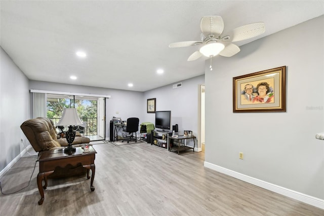 living room featuring ceiling fan and light hardwood / wood-style floors