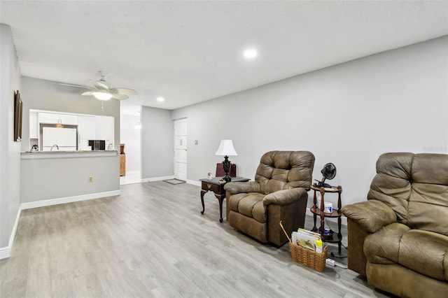 living room with ceiling fan and light hardwood / wood-style floors