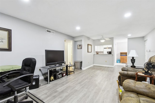 living room with light hardwood / wood-style floors and ceiling fan