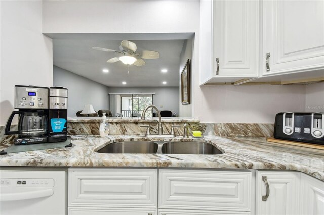 kitchen with white cabinets, white dishwasher, sink, ceiling fan, and light stone counters