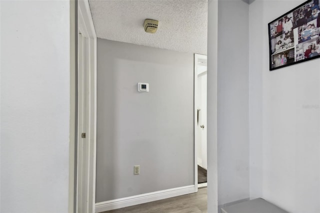 hallway with wood-type flooring and a textured ceiling