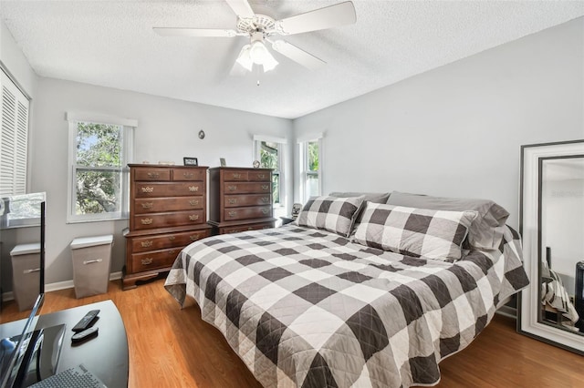 bedroom featuring hardwood / wood-style flooring, ceiling fan, and a textured ceiling