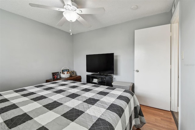 bedroom featuring ceiling fan, a textured ceiling, and hardwood / wood-style flooring