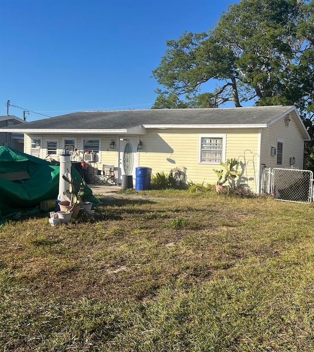 rear view of house featuring a lawn