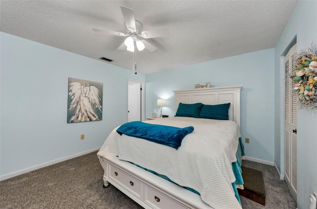 carpeted bedroom with ceiling fan and a textured ceiling