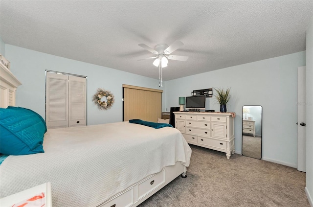 carpeted bedroom featuring ceiling fan and a textured ceiling