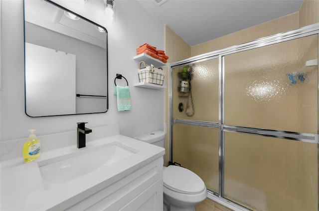 bathroom with vanity, toilet, and an enclosed shower