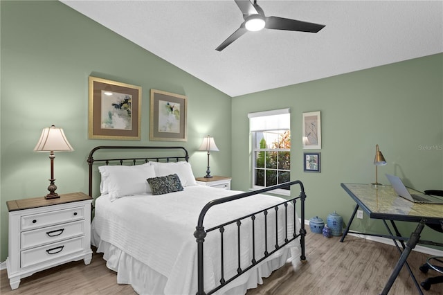 bedroom with vaulted ceiling, a textured ceiling, and light hardwood / wood-style floors