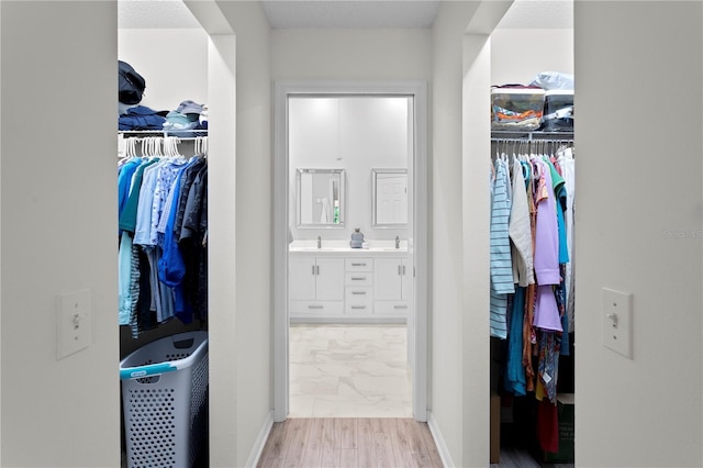 walk in closet featuring sink and light hardwood / wood-style floors