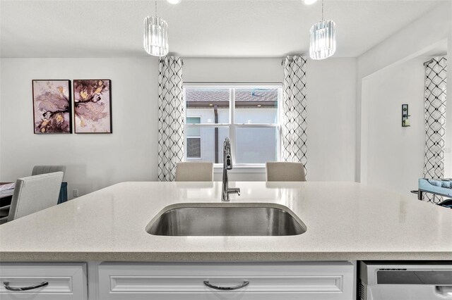 kitchen featuring decorative light fixtures, sink, and stainless steel dishwasher