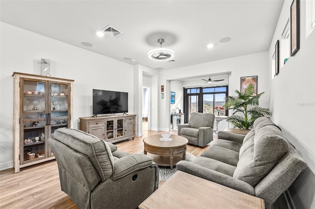 living room with light hardwood / wood-style floors and ceiling fan