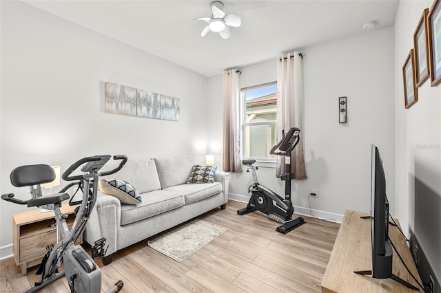 exercise room with ceiling fan and light hardwood / wood-style flooring