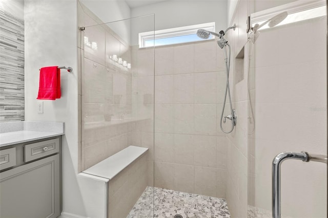 bathroom with a shower with shower door and vanity