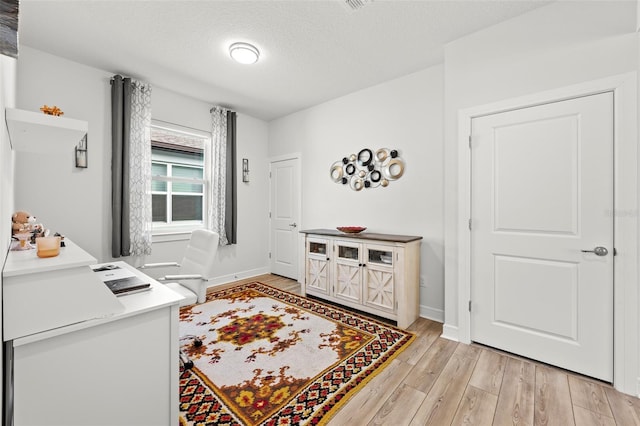 interior space with light hardwood / wood-style floors and a textured ceiling