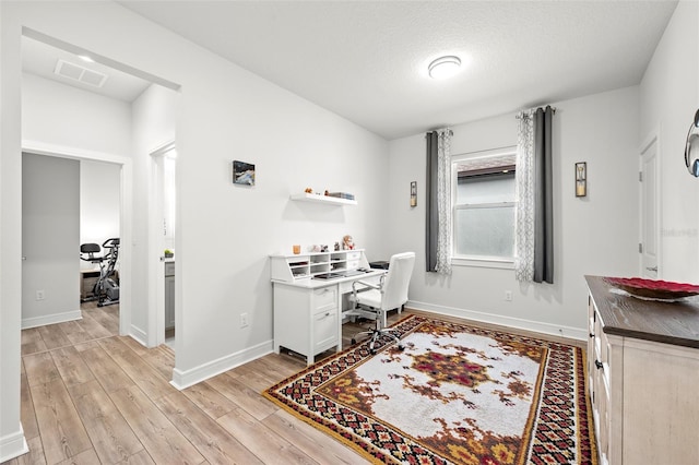 office with a textured ceiling and light hardwood / wood-style flooring