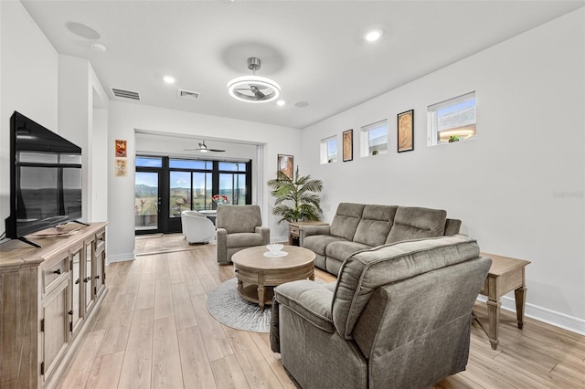 living room featuring ceiling fan and light hardwood / wood-style flooring