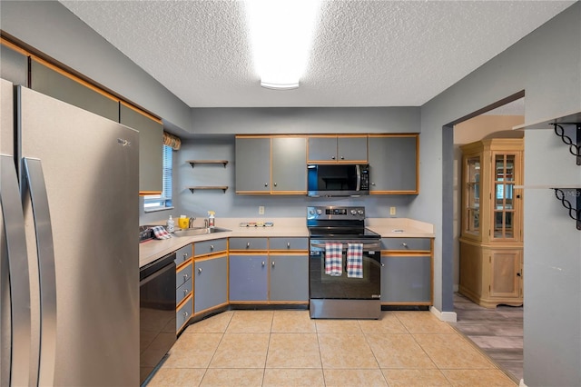 kitchen featuring black appliances, sink, gray cabinets, light tile patterned floors, and a textured ceiling