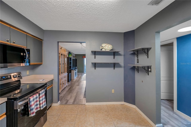 kitchen featuring gray cabinets, electric stove, a textured ceiling, and light tile patterned floors