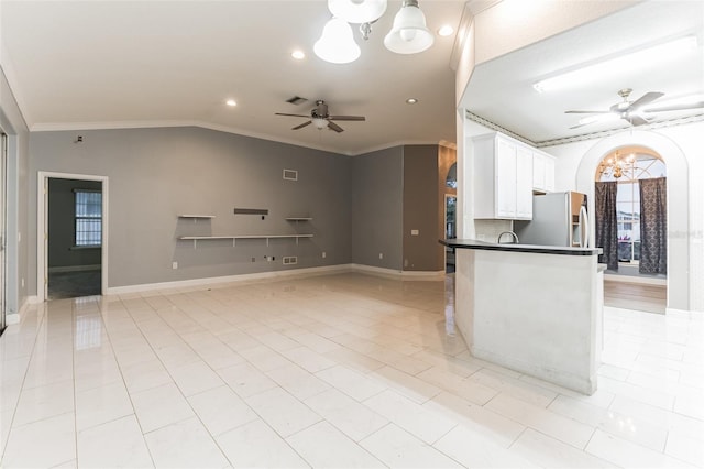 kitchen featuring ornamental molding, ceiling fan with notable chandelier, white cabinets, stainless steel fridge with ice dispenser, and lofted ceiling