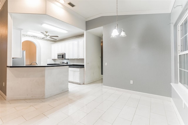 kitchen featuring white cabinets, decorative backsplash, pendant lighting, and ceiling fan with notable chandelier