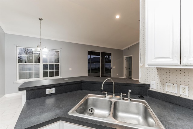 kitchen with pendant lighting, sink, vaulted ceiling, light tile patterned floors, and white cabinetry