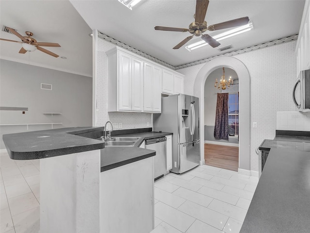 kitchen with kitchen peninsula, stainless steel appliances, ceiling fan, sink, and white cabinetry