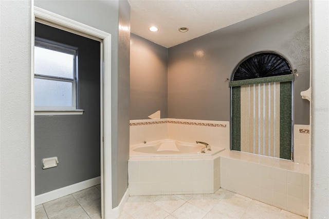 bathroom with tile patterned flooring and tiled tub