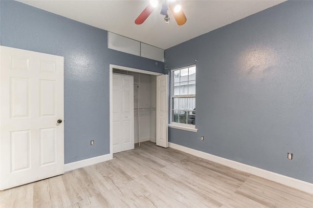 unfurnished bedroom featuring ceiling fan, a closet, and light wood-type flooring