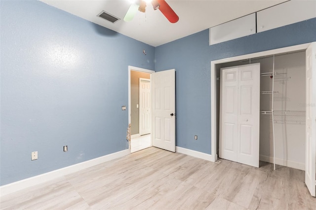 unfurnished bedroom featuring ceiling fan, a closet, and light wood-type flooring