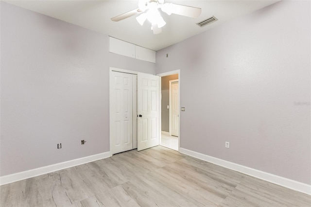 unfurnished bedroom featuring ceiling fan, light wood-type flooring, and a closet