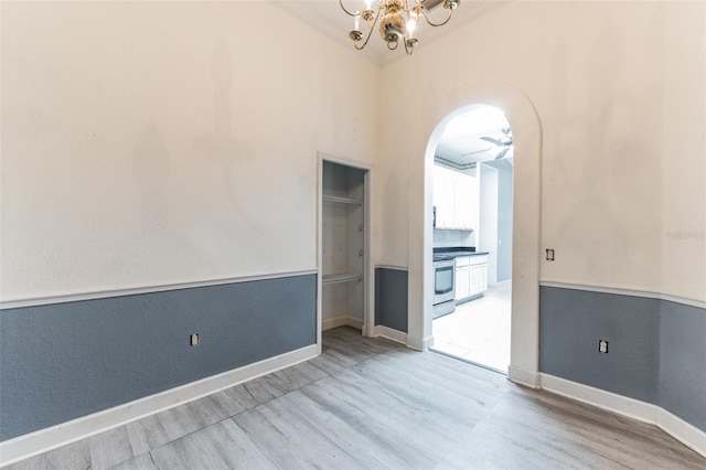 spare room with hardwood / wood-style floors and ceiling fan with notable chandelier