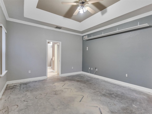 spare room with ceiling fan, ornamental molding, and a tray ceiling