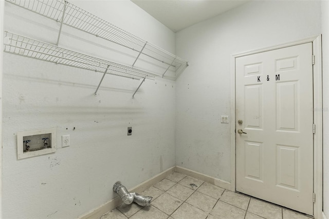 laundry area with hookup for an electric dryer, light tile patterned floors, and washer hookup