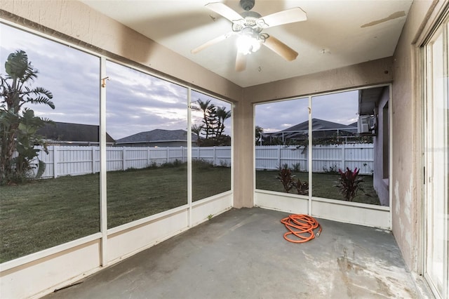 unfurnished sunroom featuring a mountain view and ceiling fan