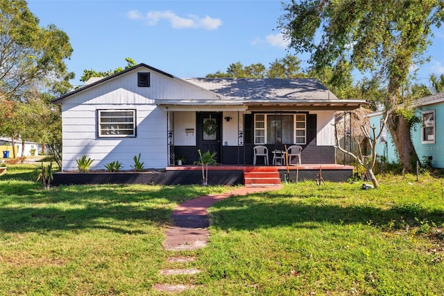 bungalow with covered porch and a front yard