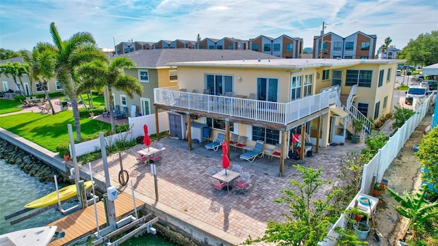 rear view of house featuring a water view, a balcony, and a patio