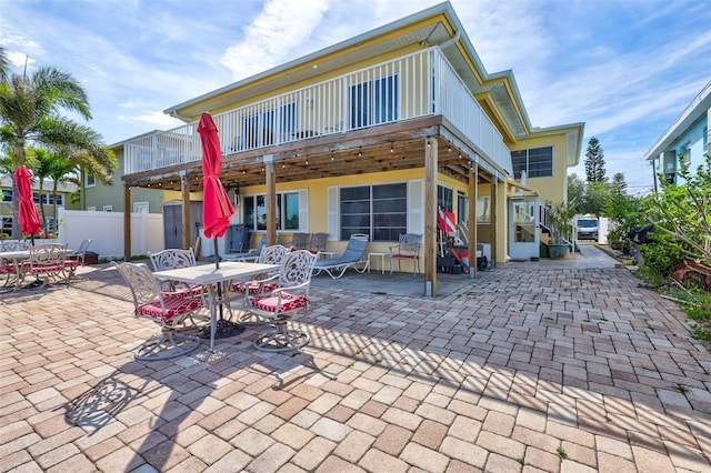 rear view of property featuring a patio area and a deck