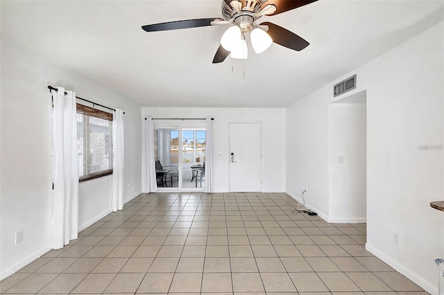 empty room with ceiling fan and light tile patterned flooring