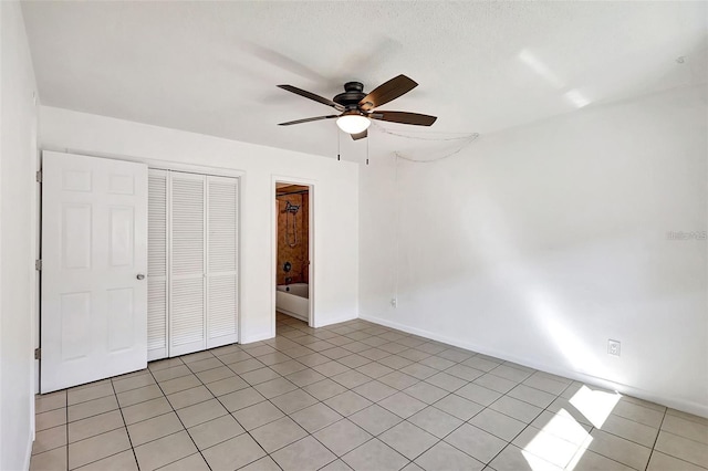 unfurnished bedroom featuring light tile patterned floors, connected bathroom, a closet, and ceiling fan