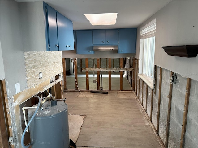 kitchen featuring a skylight, blue cabinets, and light hardwood / wood-style flooring