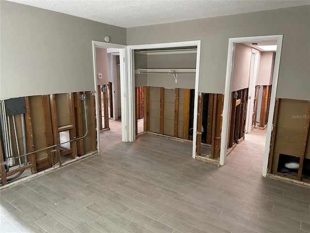 interior space featuring hardwood / wood-style floors, a textured ceiling, and a closet